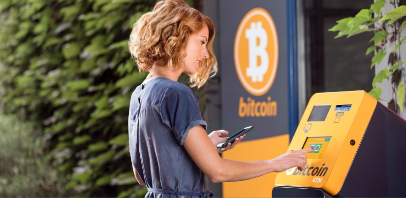 Žena podiže novac na bitcoin bankomatu